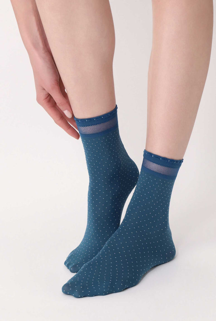 Front veow of lady's feet wearing cobalt blue and white dot socks.