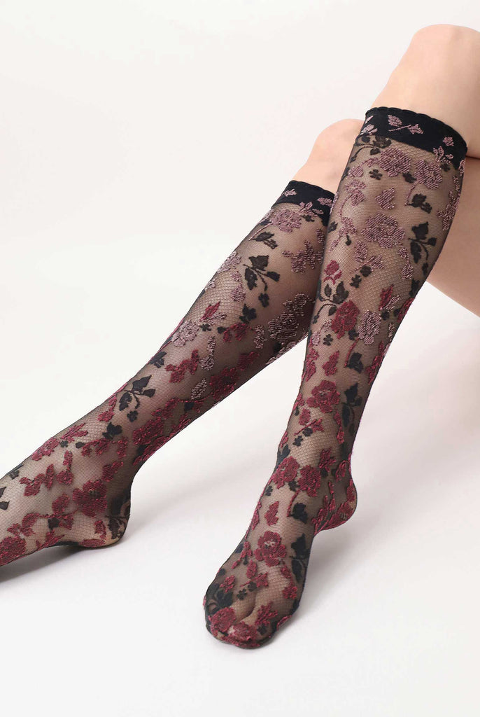 Front view of lady's lower legs in floral lace red and black sheer knee highs.