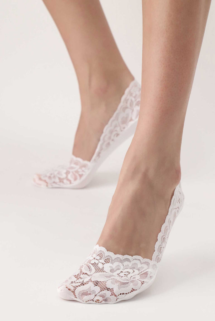 Front view of lady's feet in white lace foot protectors.