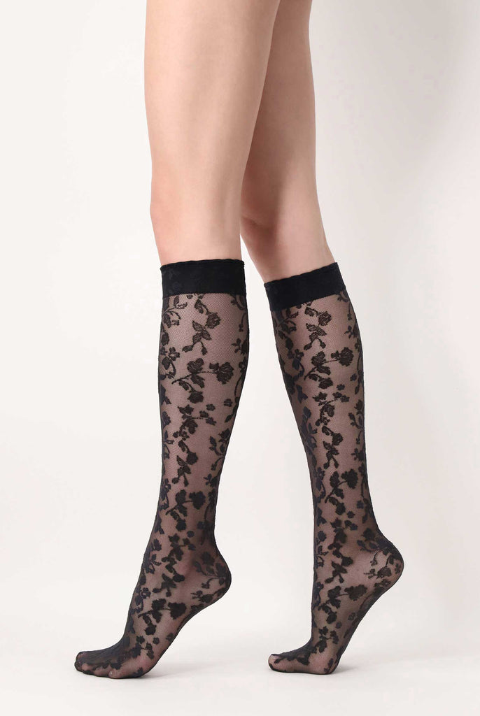 Side view of lady's legs wearing black lace knee highs.