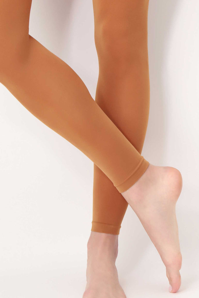 Close up of lady's lower legs and feet, in sienna coloured footless tights.