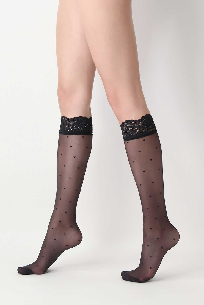 Lady's legs in walking stance, in black, heart pattern, sheer long socks.