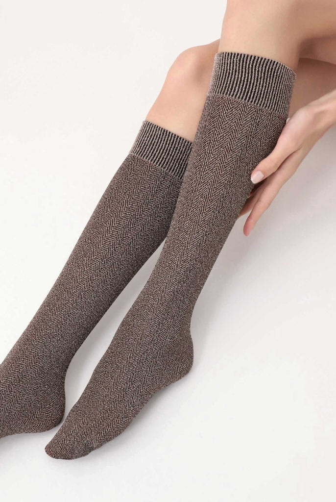 Front view of lady's outstretched lower legs wearing brown tweed socks.
