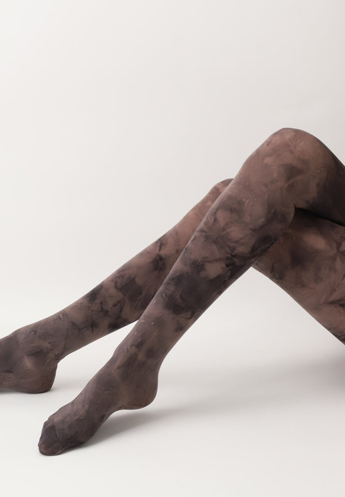 Lady's legs outstretched and crossed in brown tie dye tights.
