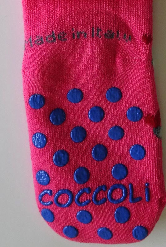 Coccoli pink grip socks displaying blue grips on back sole.