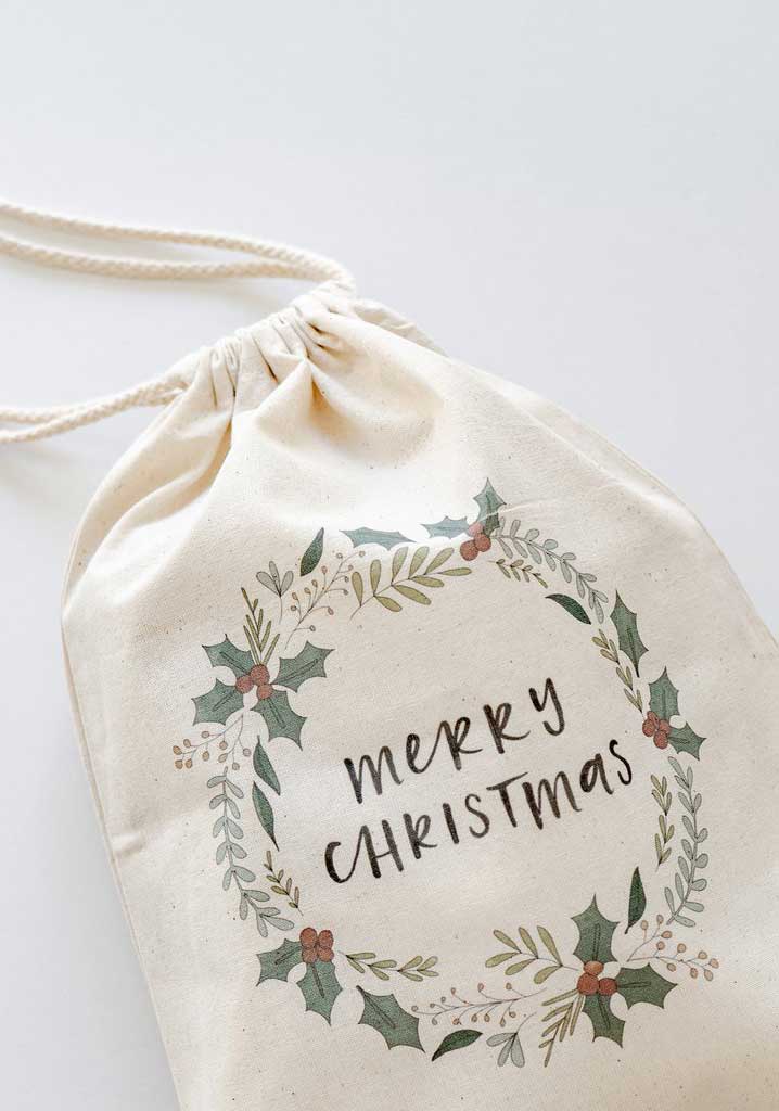 Canvas Christmas gift bag with draw string and printed Merry Christmas slogan.