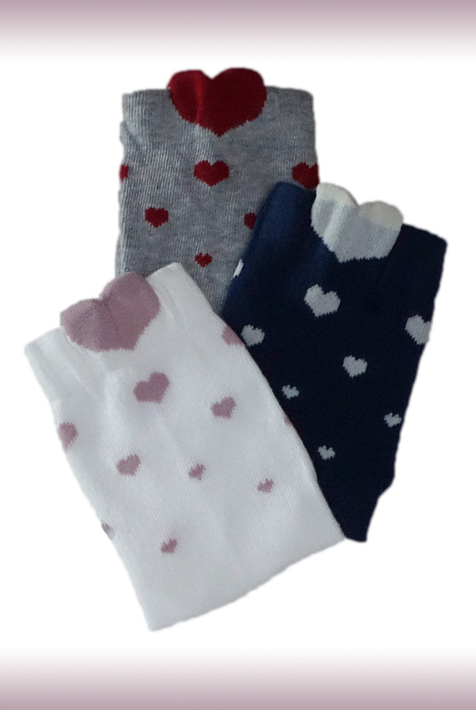 Three pairs of Coccoli Children's socks in navy, white and grey with heart prints.