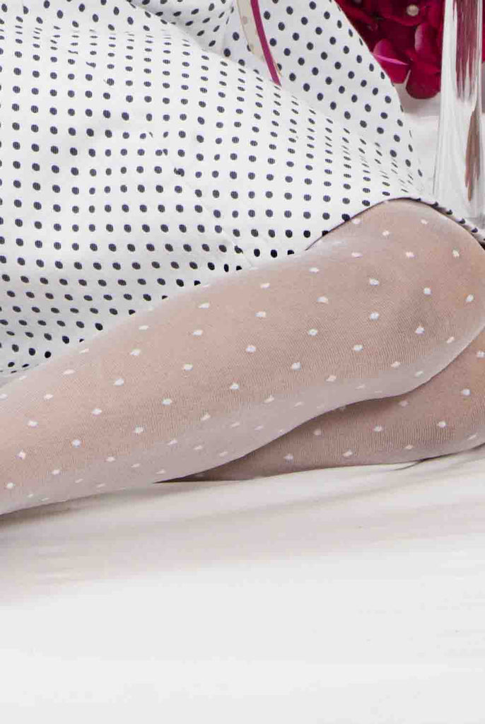 Close up of a girl's leg wearing white dot tights.