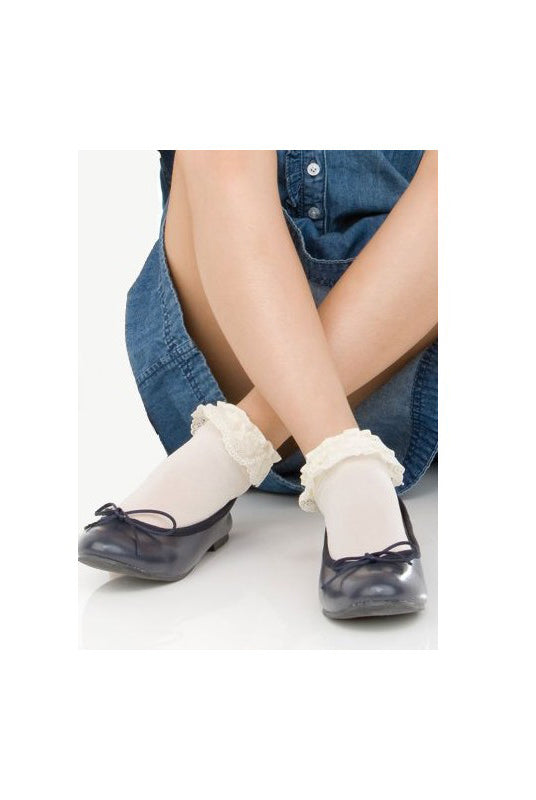 Girl's legs crossed at the ankles wearing a blue denim dress and white frilly ankle socks in black ballerina flats.