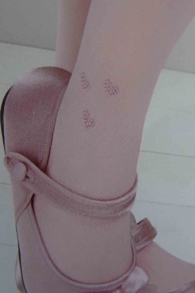 A girl's lower leg and ankle wearing baby pink tights with three pink rhinestone hearts appliquéd onto tights.