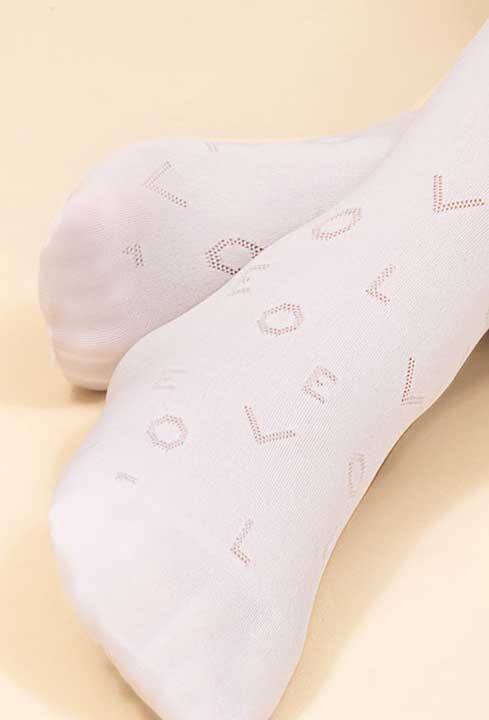 Close up of a girl's foot with the phrase love patterned all over the tights.