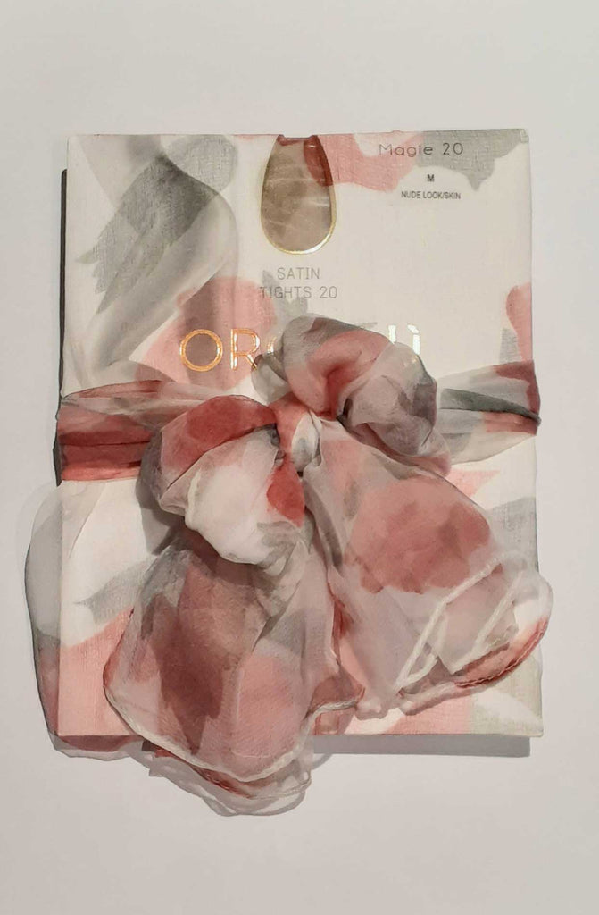 White, grey and pink sheer scarf used as gift wrap.
