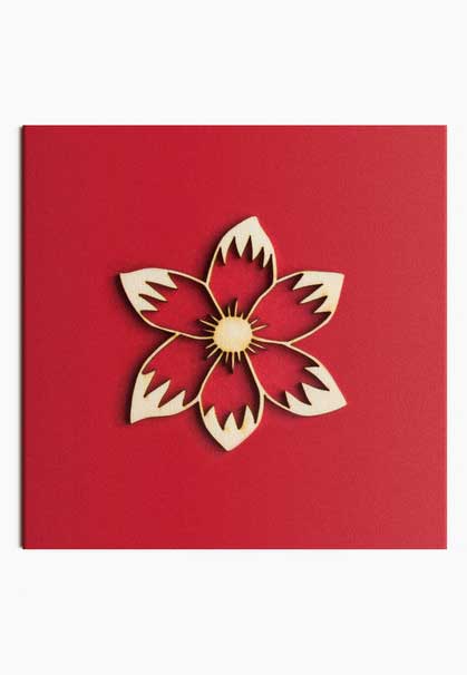 Decorative wooden flower on red cardboard.