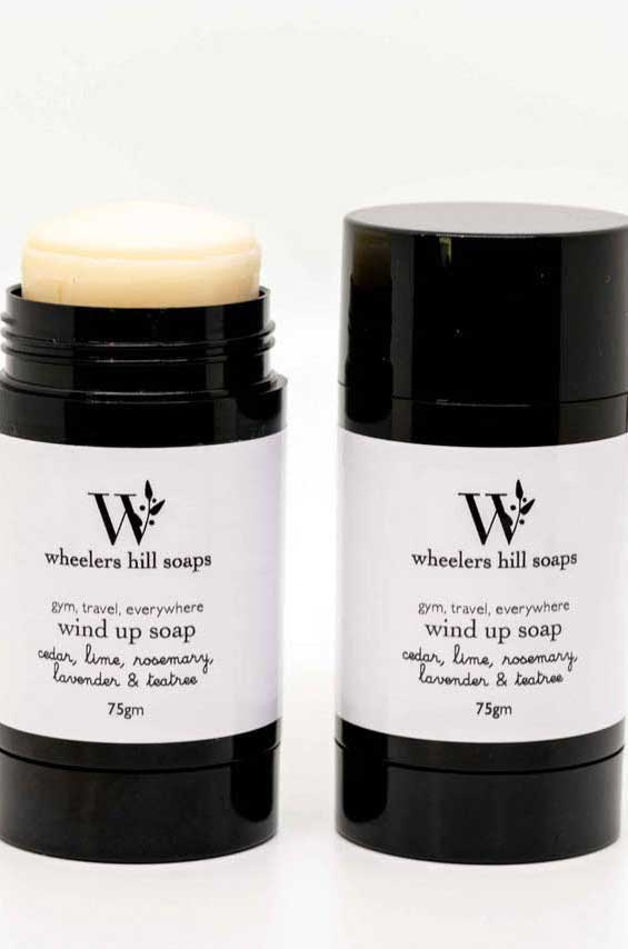 Two wind up soap bars in black containers.