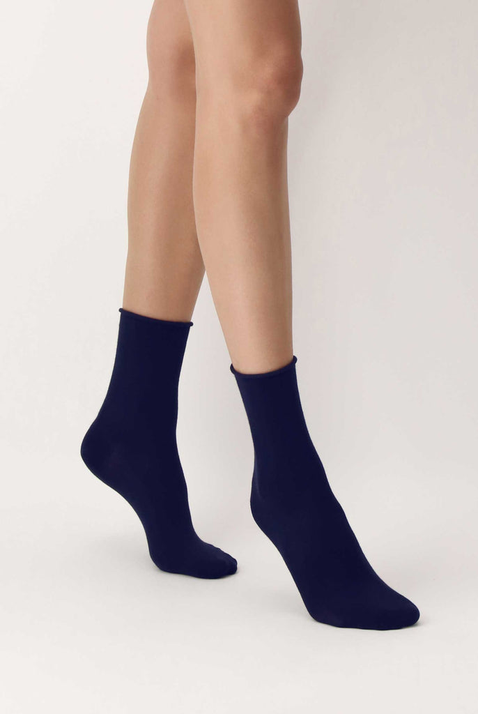 Lady's feet in walking motion on tip toes in dark blue socks.