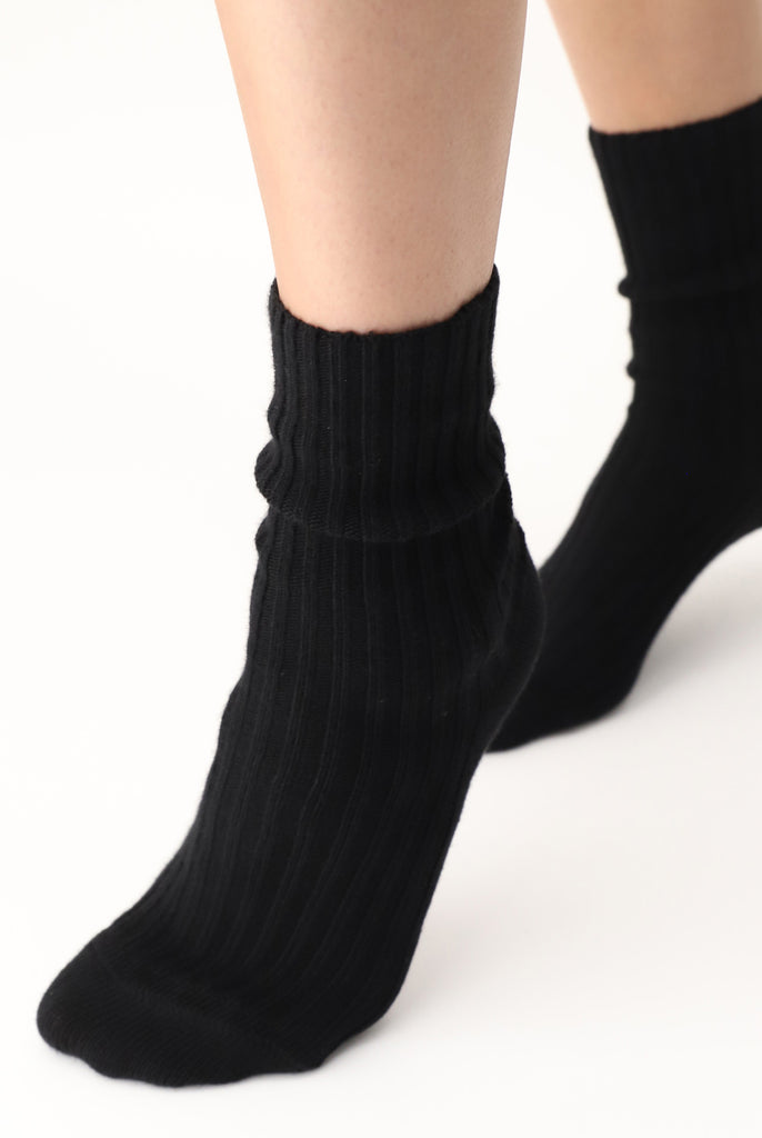 Close up of lady's feet on tip toes in black socks.