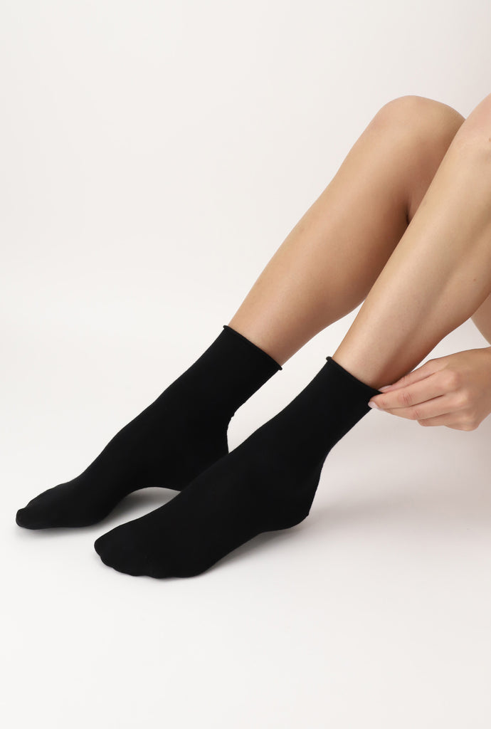 Lady's legs and feet outstretched, wearing black socks.