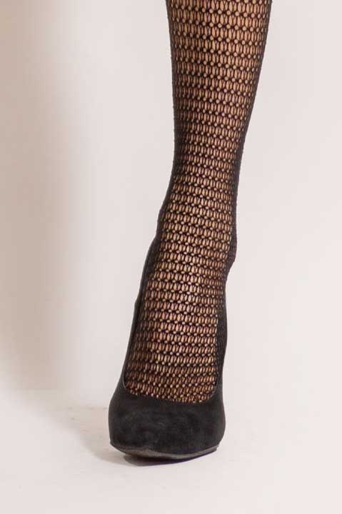 Close up of lady's foot in black velvet heel and black fishnets