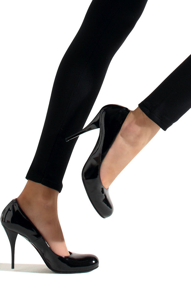 Close up of lady's ankles and feet in black leggings and shoes.