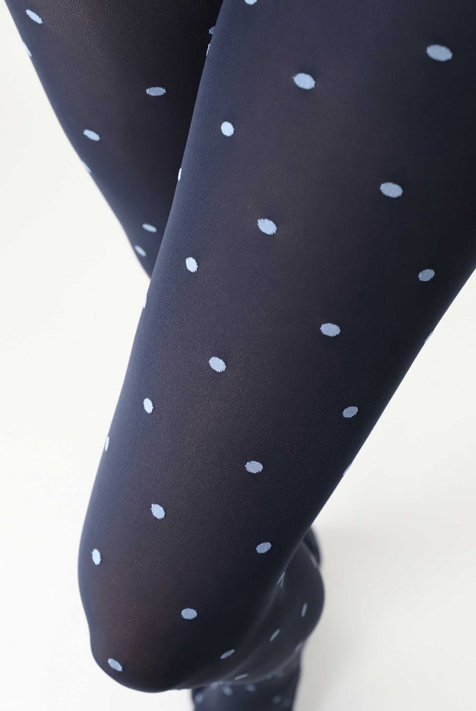 Close up of lady's upper leg in black and sky blue dot tights.
