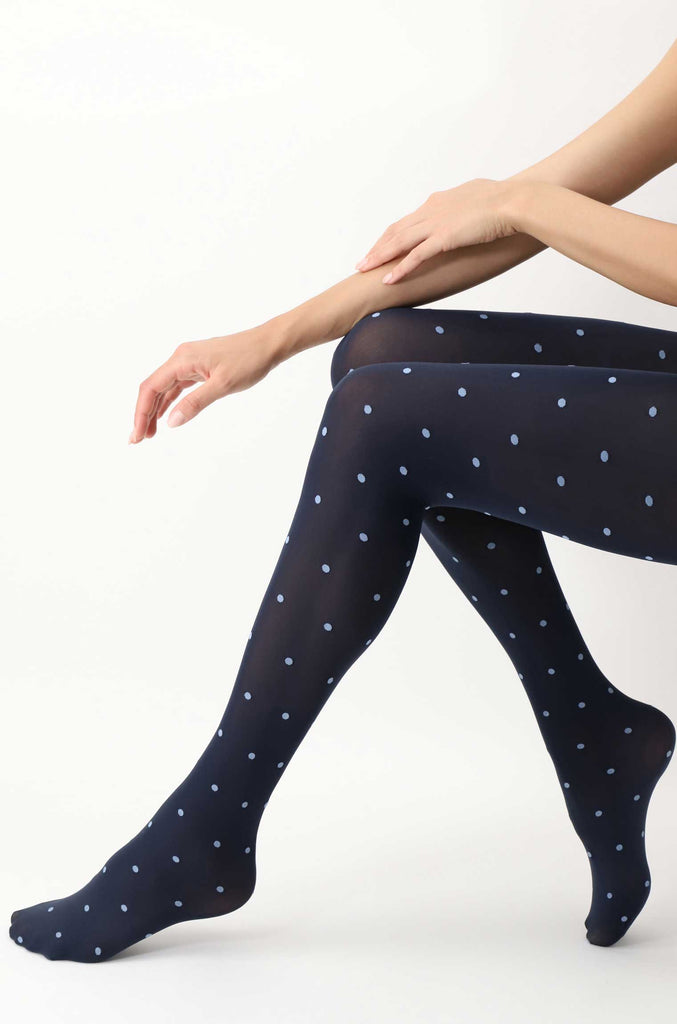 Lady's legs outstretched in sitting position, in black and blue spotty tights.