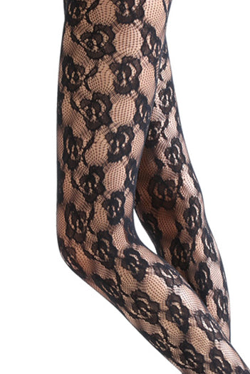 Close up of lady's upper and lower leg in black lace flower mesh tights.