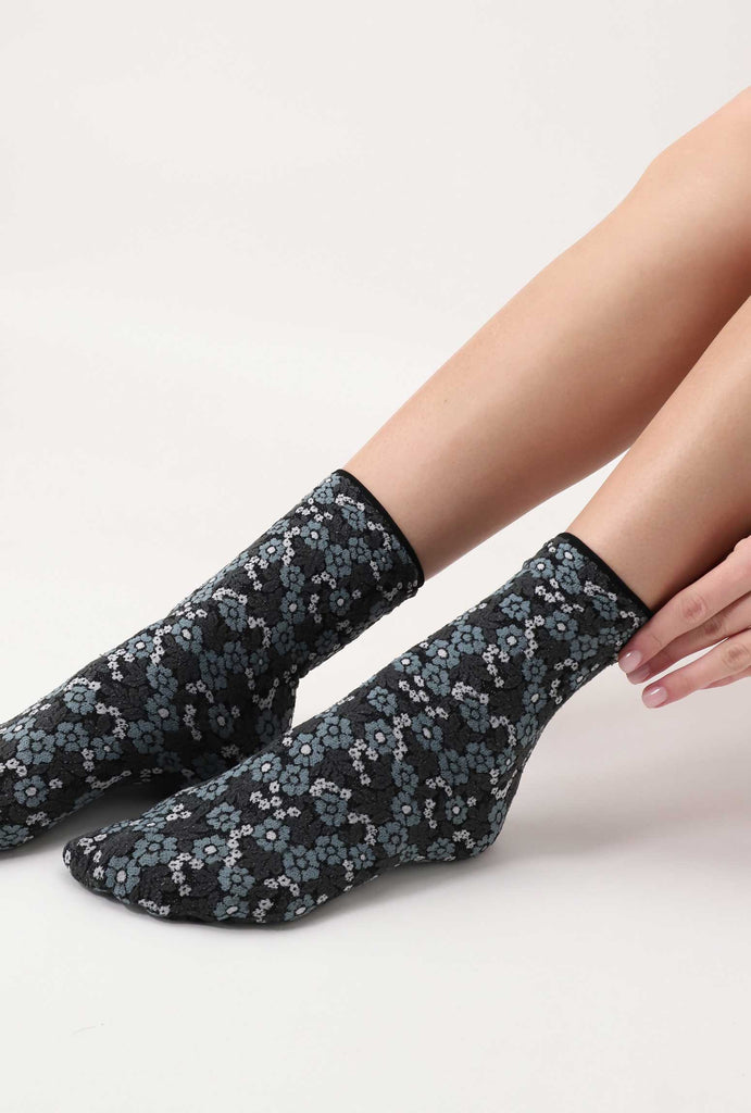 Lady's feet outstretched wearing blue /grey flower print socks.