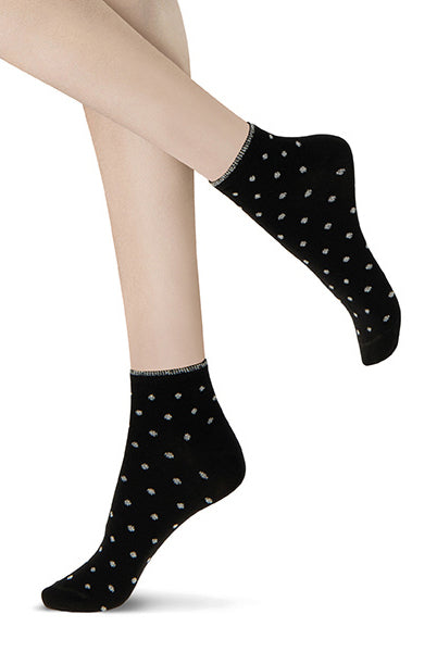 Close up of lady's feet wearing black and silver patterned ankle socks.