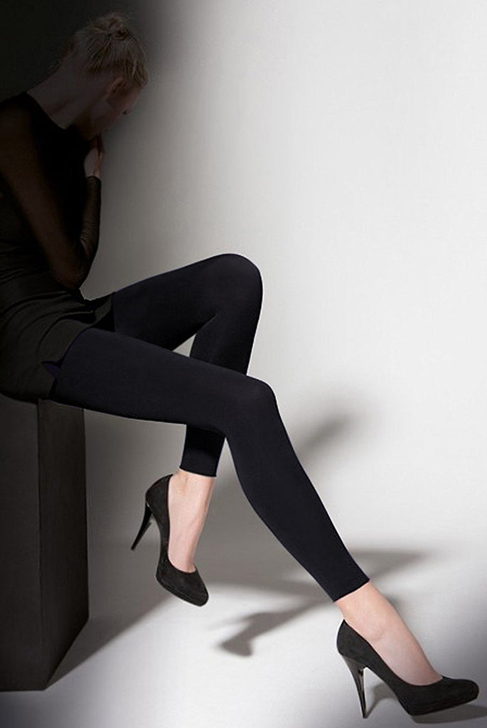 Ladies legs outstretched wearing black footless tights and black heels.