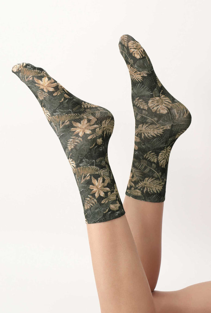 Lady's feet swinging in the air, wearing green and gold jungle print socks.