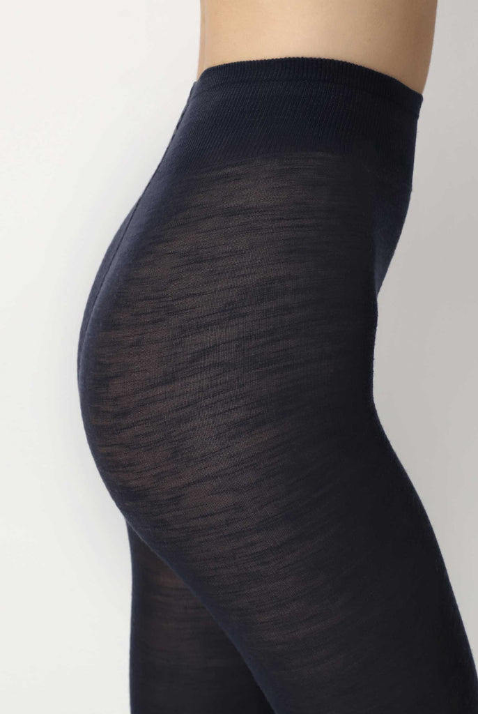 Close up view of lady's side abdomen in dark blue tights.