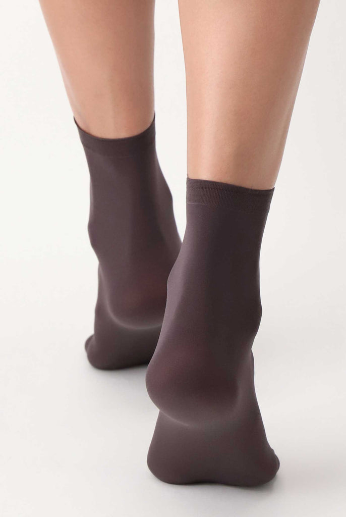 Back view of lady's feet in brown socks.