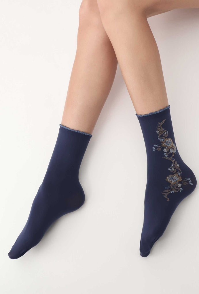 Lady's feet outstretched, wearing blue floral patterned socks.