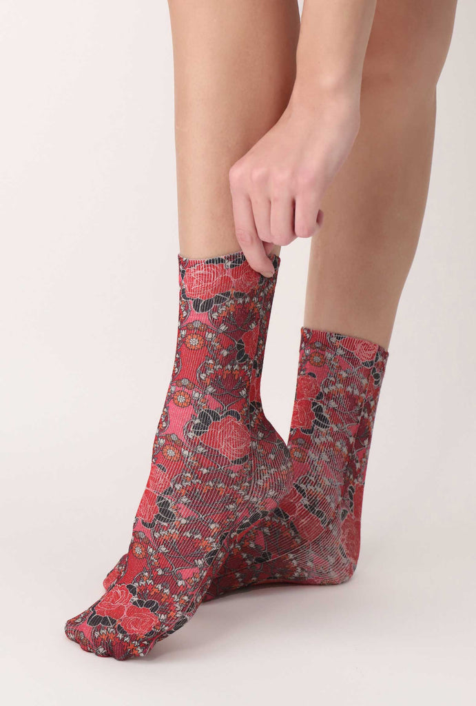 Lady's feet wearing rose print sparkly socks.