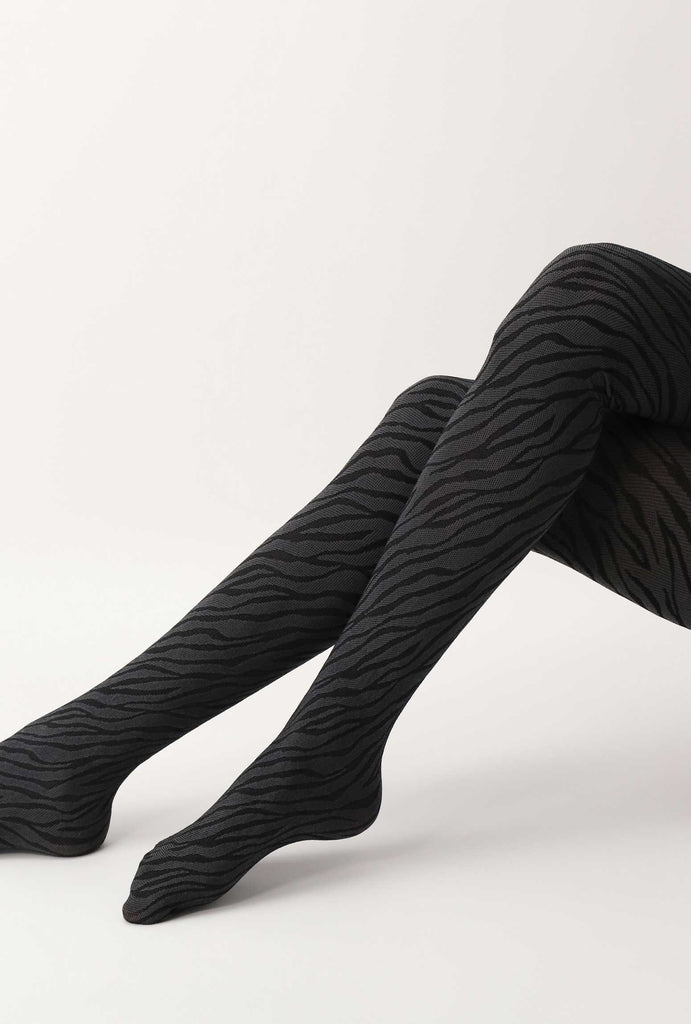 Lady's legs outstretched in snake print tights.