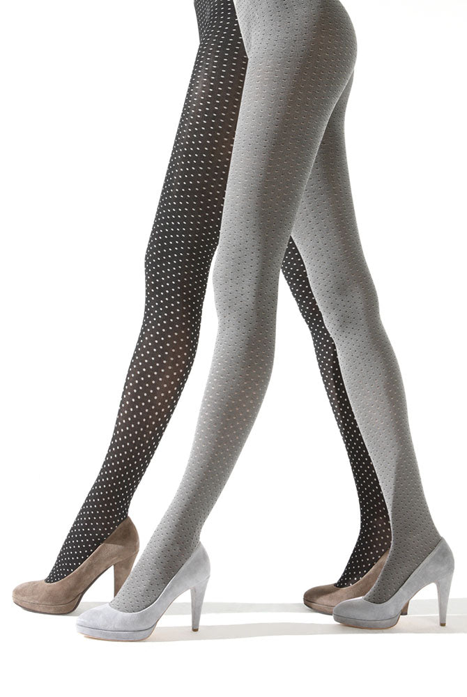 Side view of lady's legs walking and wearing white and black spotty tights Deliziosa tights by Franzoni.