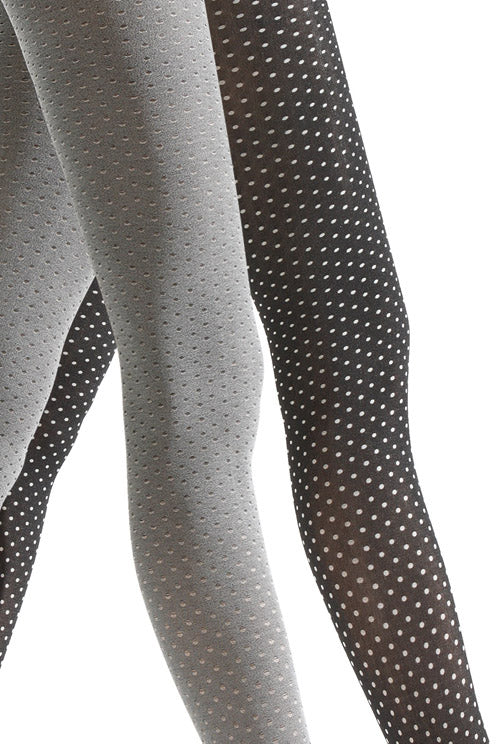 Close up of side view of lady's legs walking and wearing white and black dot tights.