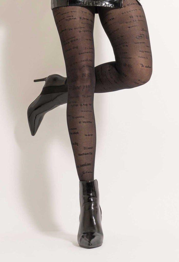 Lady standing with one leg up in black sheer writing patterned tights.
