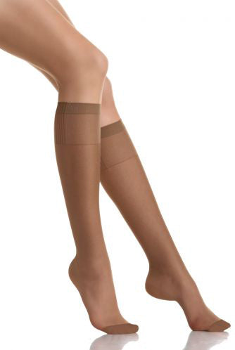 Lady's leg's outstretched wearing nude sheer knee highs.