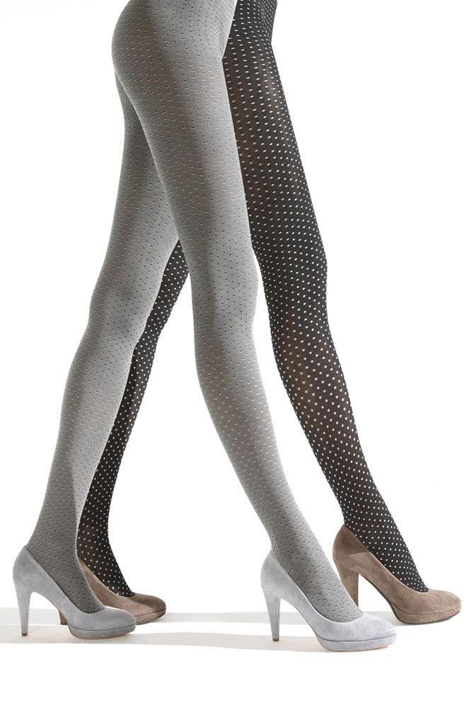 Side view of lady's legs walking and wearing white and black spotty tights.