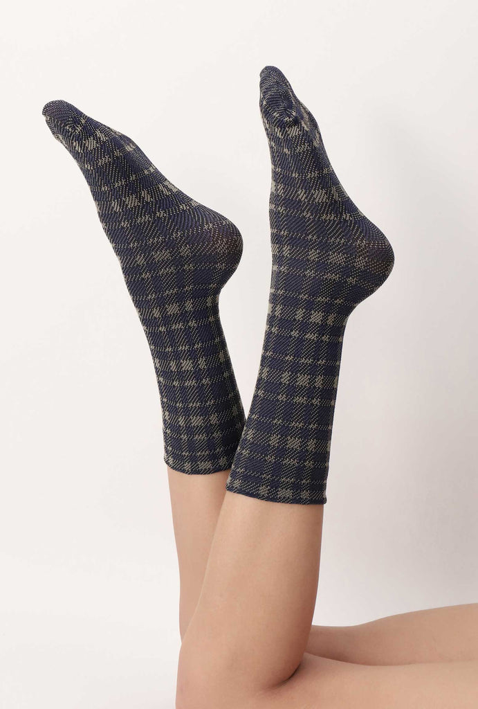 Lady's feet swinging in the air in blue/grey tartan socks.