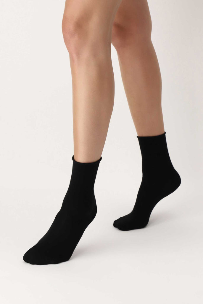 Lady's feet in walking motion in black socks.