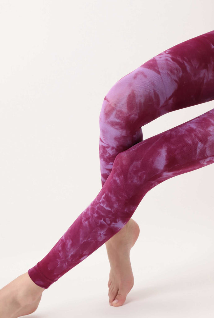 Outstretched lady's legs in lilac pink tie-dye footless tights.