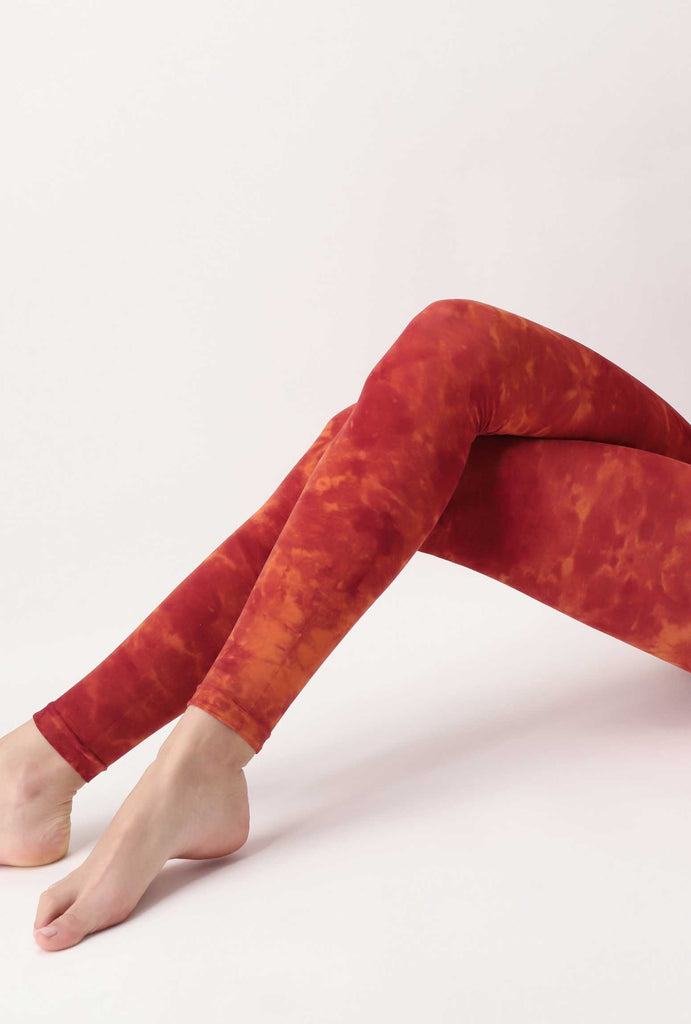 Outstretched lady's legs in orange tie-dye footless tights.  