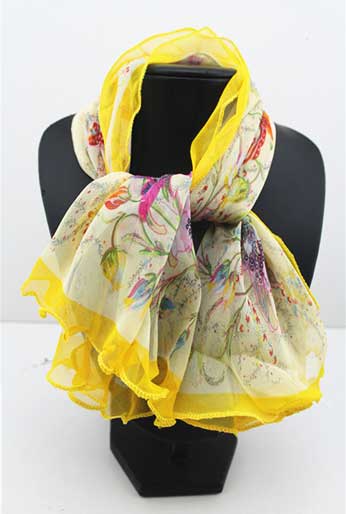 Yellow and colour flower print scarf tied around black bust stand.